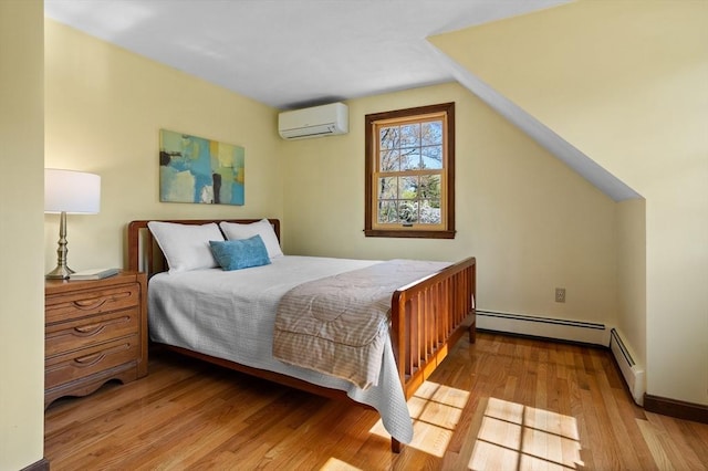 bedroom featuring an AC wall unit, light wood-style flooring, and a baseboard heating unit