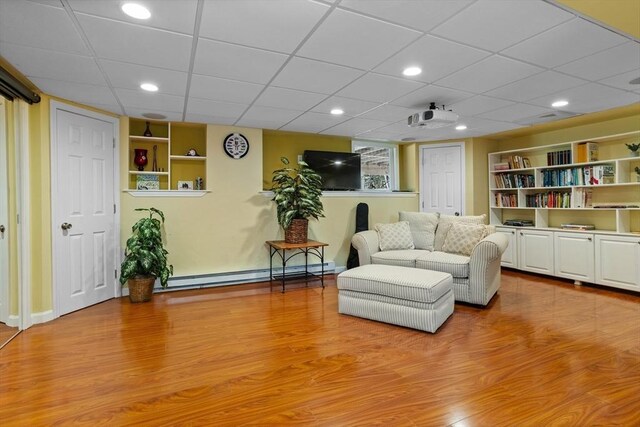 living room featuring a baseboard radiator, wood finished floors, baseboards, built in features, and recessed lighting