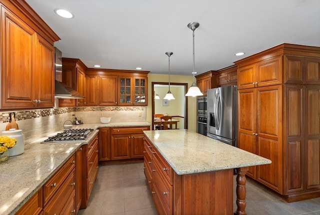 kitchen with appliances with stainless steel finishes, dark tile patterned floors, backsplash, brown cabinets, and recessed lighting