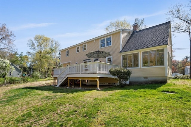 rear view of property featuring stairway, a wooden deck, roof with shingles, a chimney, and a lawn