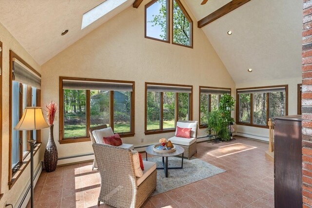 sunroom with a skylight, high vaulted ceiling, a baseboard heating unit, stone finish floors, and beamed ceiling