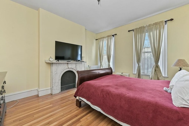 bedroom featuring light hardwood / wood-style flooring and a fireplace