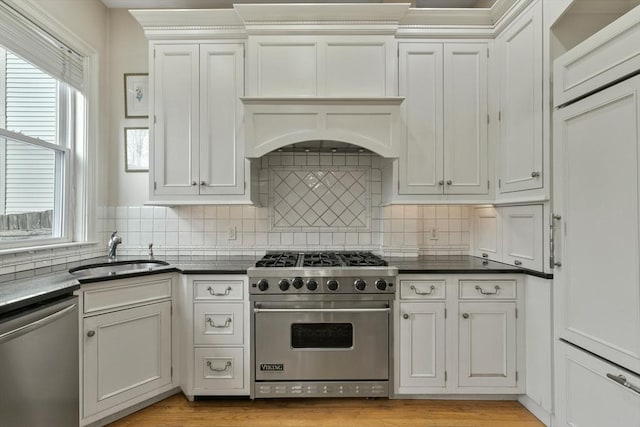 kitchen featuring sink, backsplash, white cabinetry, and appliances with stainless steel finishes