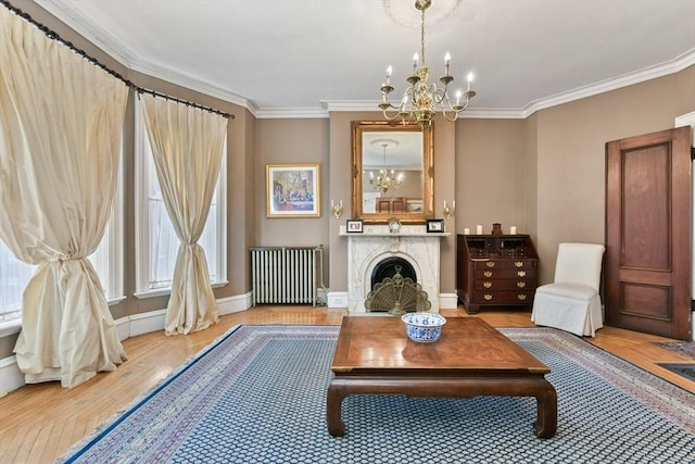 living area featuring light hardwood / wood-style flooring, radiator heating unit, ornamental molding, and an inviting chandelier