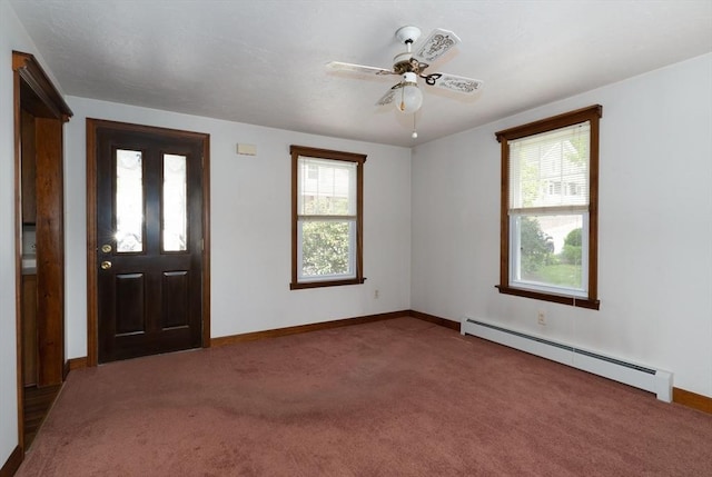 carpeted foyer entrance with baseboard heating, plenty of natural light, baseboards, and a ceiling fan