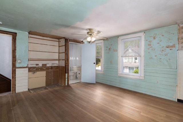 unfurnished living room with wood finished floors and ceiling fan