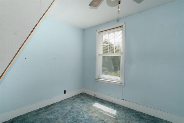 carpeted spare room with ceiling fan and baseboards
