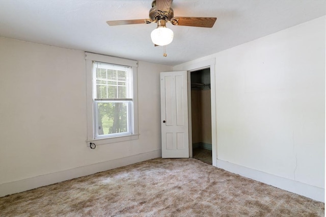 unfurnished bedroom with carpet flooring, baseboards, ceiling fan, and a closet