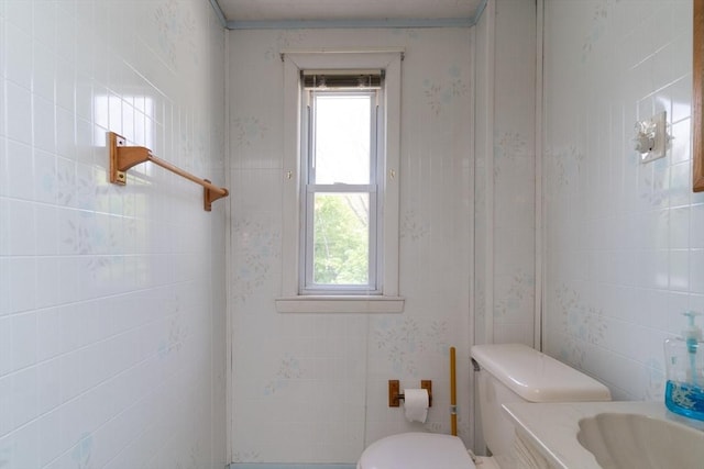 bathroom with toilet and wallpapered walls