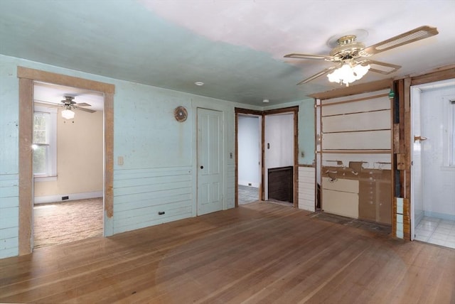 unfurnished living room featuring a ceiling fan and wood finished floors