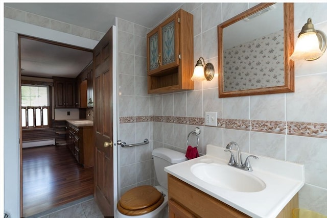 bathroom with baseboard heating, toilet, and vanity