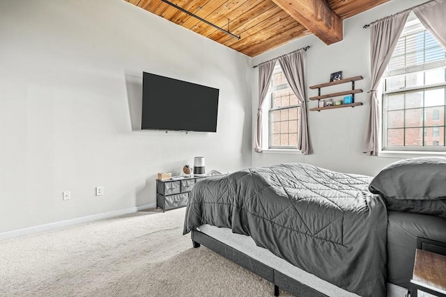 carpeted bedroom with beamed ceiling, baseboards, and wood ceiling