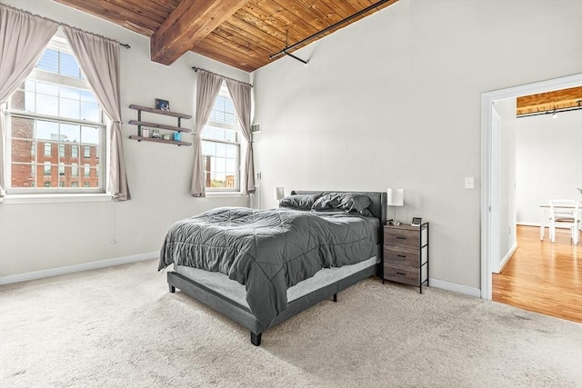 bedroom featuring wooden ceiling, baseboards, carpet, and beam ceiling