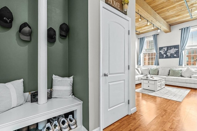 mudroom with light wood-style floors, wooden ceiling, beam ceiling, and track lighting