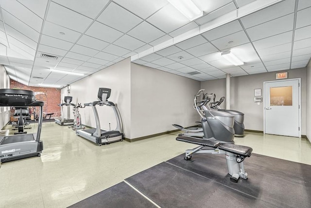 exercise room featuring baseboards, a drop ceiling, and visible vents