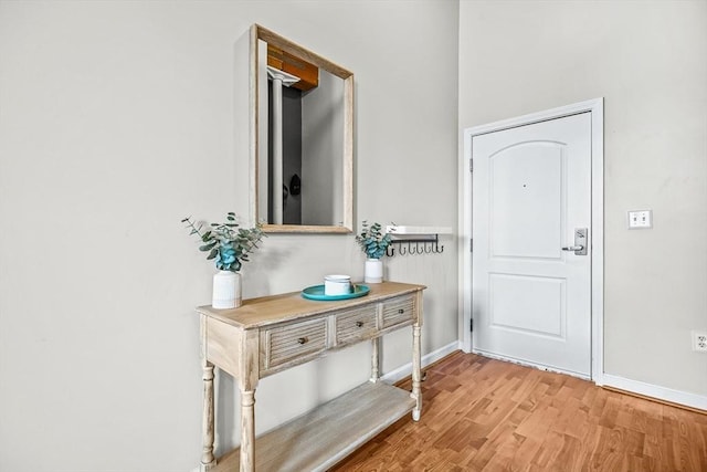 foyer with baseboards and light wood-style flooring