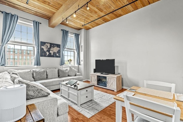 living room with track lighting, wood ceiling, light wood finished floors, and beamed ceiling