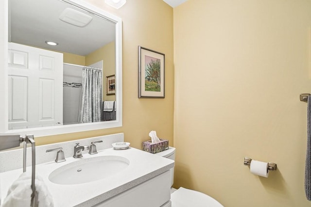 bathroom with toilet, vanity, and a shower with shower curtain