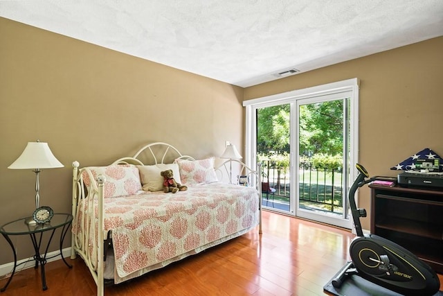 bedroom with access to exterior and wood-type flooring