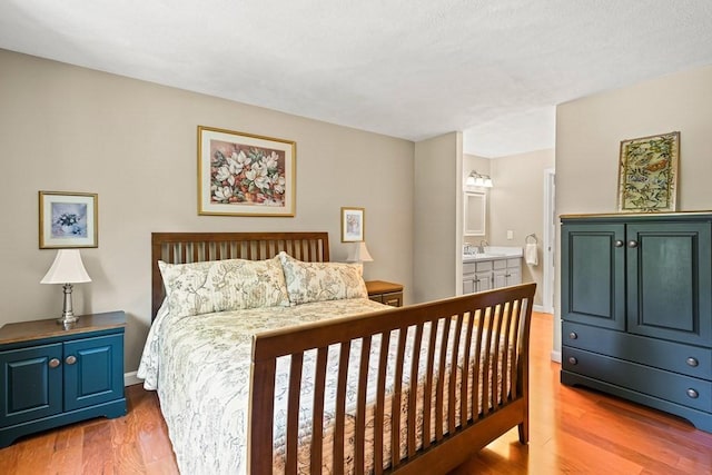 bedroom featuring hardwood / wood-style flooring, sink, and connected bathroom