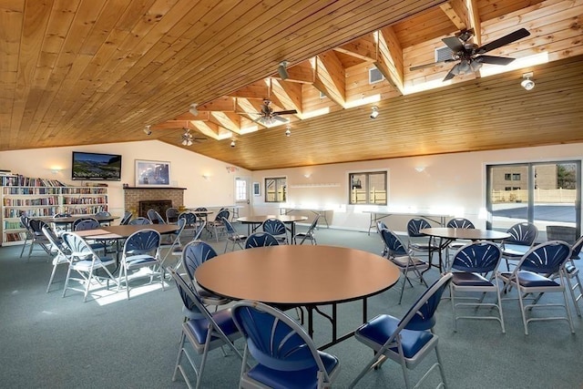 dining space with vaulted ceiling with skylight, plenty of natural light, and wood ceiling