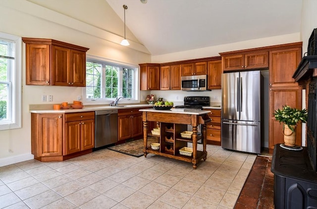kitchen featuring brown cabinetry, light countertops, appliances with stainless steel finishes, and light tile patterned flooring