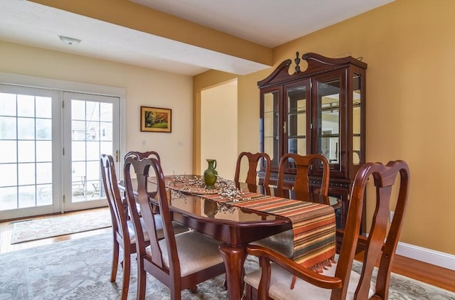 dining space featuring baseboards and wood finished floors