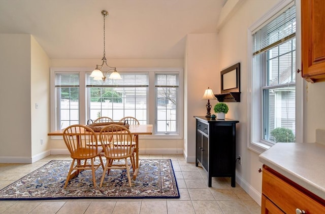 dining room featuring plenty of natural light, a chandelier, and baseboards