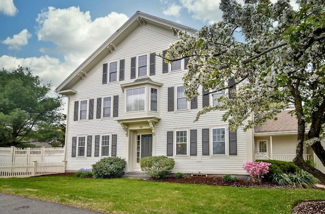 view of front of house with fence and a front lawn