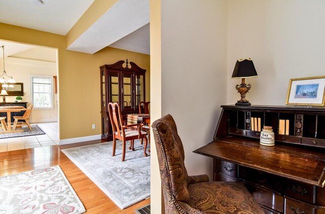 dining room with baseboards, an inviting chandelier, visible vents, and wood finished floors