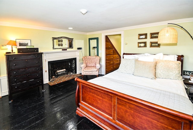 bedroom featuring crown molding and a brick fireplace