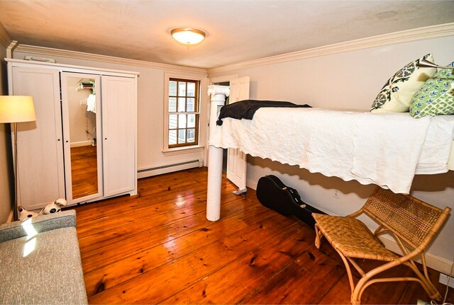 bedroom featuring crown molding, baseboard heating, a closet, and dark hardwood / wood-style flooring