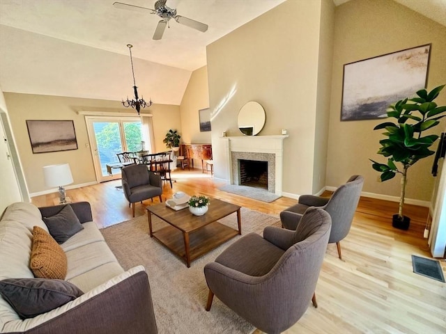 35 Mitchell Grant Way, Bedford, MA 01730 - living area with light wood-type flooring, lofted ceiling, a ceiling fan, a fireplace with raised hearth, and a chandelier