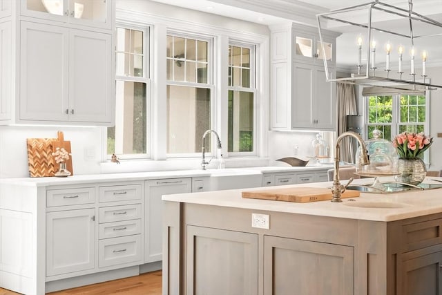 382 Lee St, Brookline, MA 02445 - kitchen featuring light countertops, a sink, white cabinets, glass insert cabinets, and recessed lighting