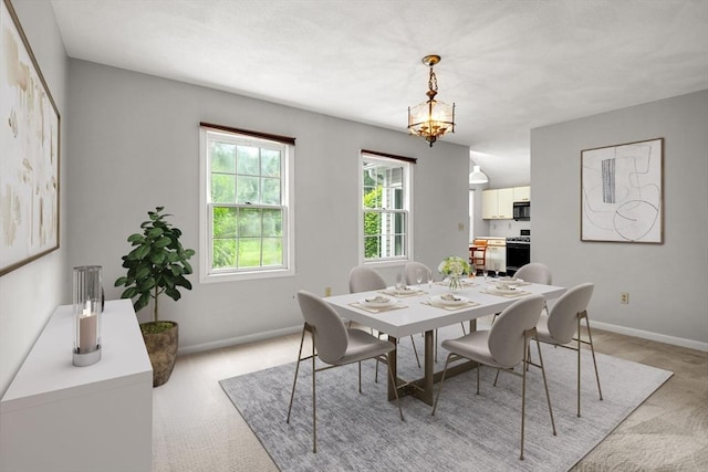 20 Ipswich Woods Dr Unit 20, Ipswich, MA 01938 - dining room with light colored carpet, baseboards, and a chandelier