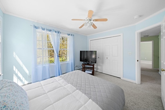 carpeted bedroom with baseboards, a closet, crown molding, and a ceiling fan