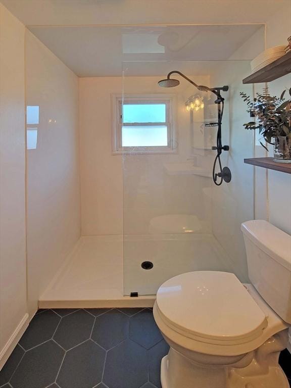 full bathroom featuring toilet, walk in shower, and tile patterned flooring