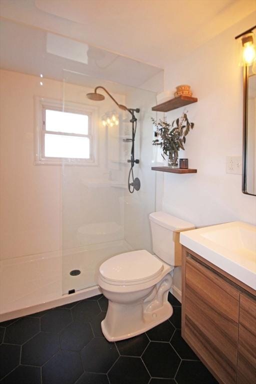 bathroom featuring tile patterned floors, toilet, walk in shower, and vanity