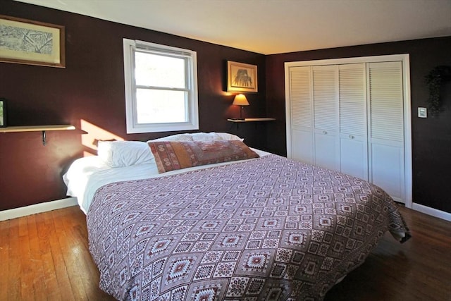 bedroom featuring wood finished floors, baseboards, and a closet