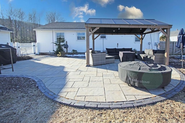 view of patio featuring outdoor lounge area, a gazebo, a gate, and fence