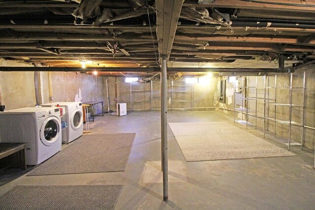 unfinished below grade area featuring washing machine and clothes dryer and electric panel