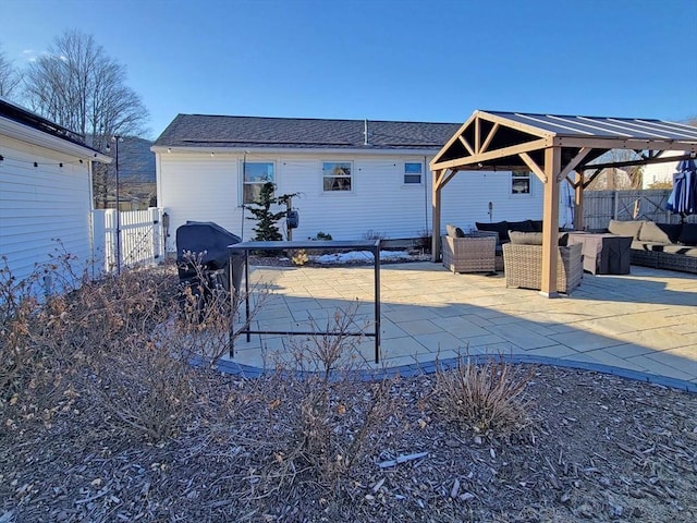 rear view of house featuring a patio area, outdoor lounge area, a gate, and fence