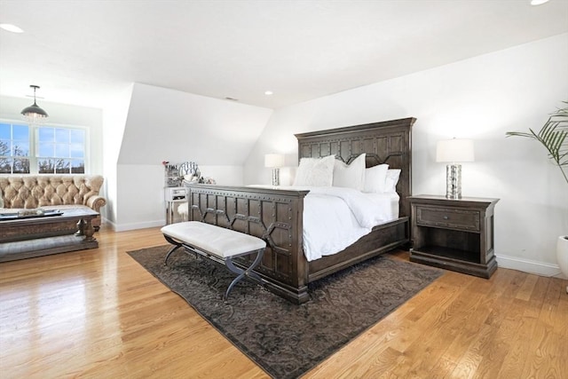 bedroom with vaulted ceiling, recessed lighting, wood finished floors, and baseboards