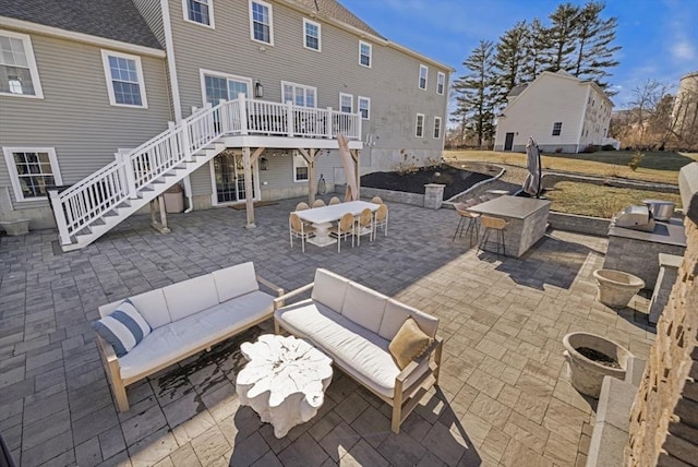 view of patio / terrace featuring area for grilling, outdoor dining space, a deck, stairway, and an outdoor hangout area