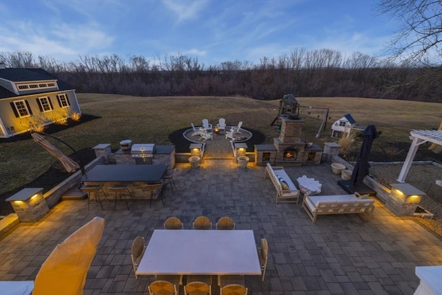 view of patio with outdoor dining space, area for grilling, a fireplace, and outdoor dry bar