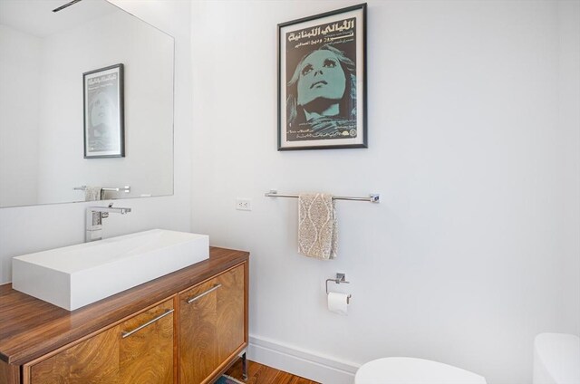 bathroom with vanity, hardwood / wood-style flooring, and toilet