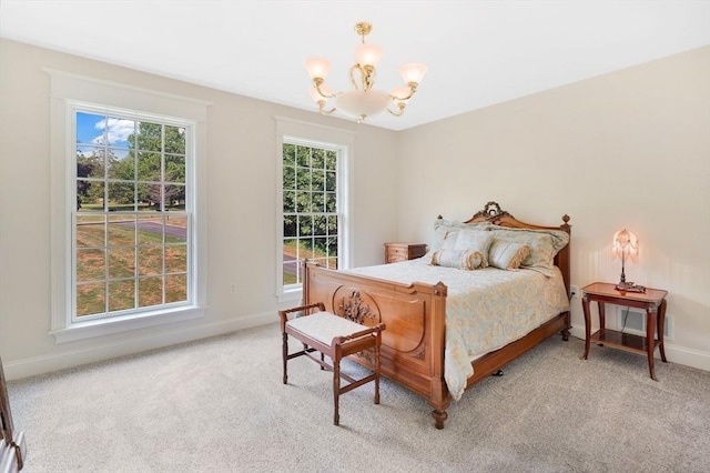 bedroom with light colored carpet, baseboards, and a notable chandelier