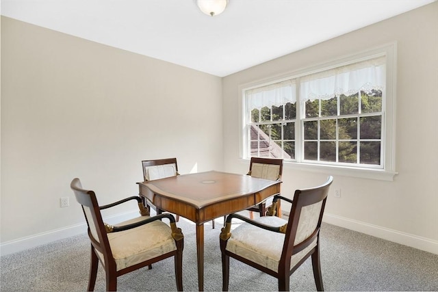 carpeted dining space with baseboards