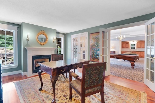 dining room featuring billiards, french doors, a fireplace with flush hearth, baseboards, and light wood finished floors
