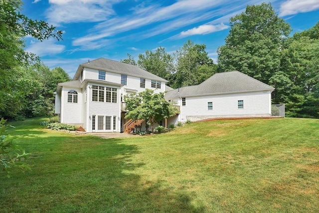 rear view of house with french doors and a yard
